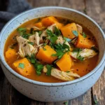 instant pot sweet potato chicken soup in a bowl garnished with fresh herbs